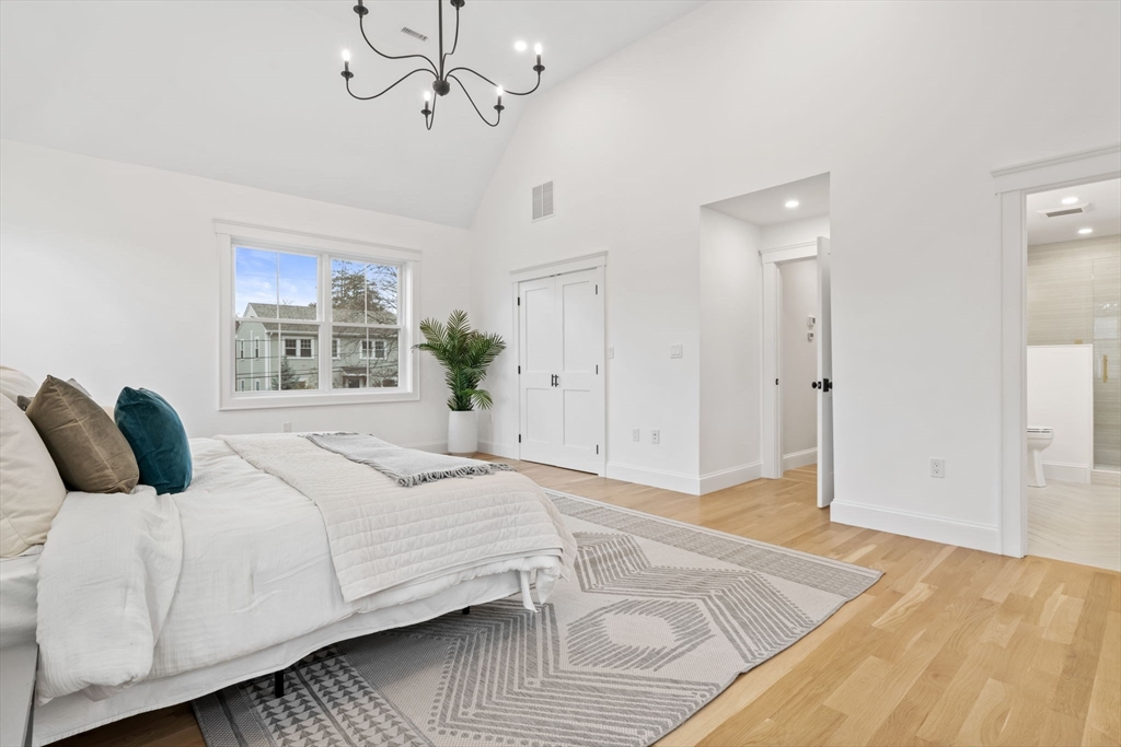 56 Valentine Road Arlington, MA 02476 - Photo 28 of 42 a bedroom with a large bed and a chandelier