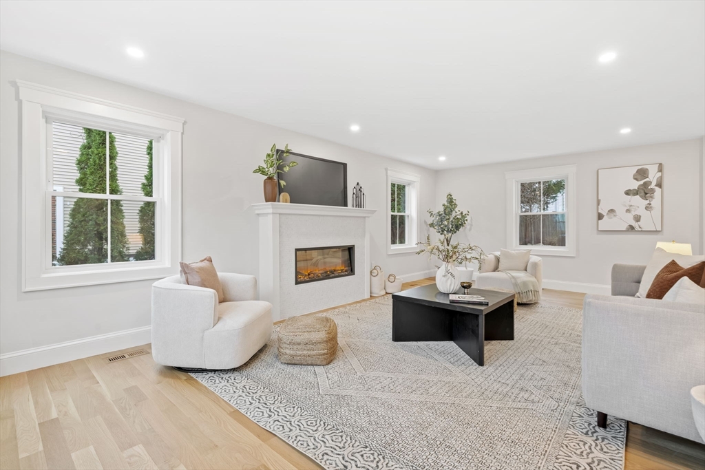 56 Valentine Road Arlington, MA 02476 - Photo 7 of 42 a living room with furniture a fireplace and a large window