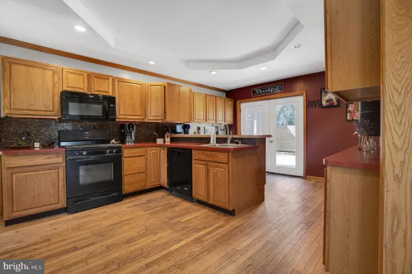 a kitchen with stainless steel appliances granite countertop a stove top oven a sink dishwasher and a refrigerator