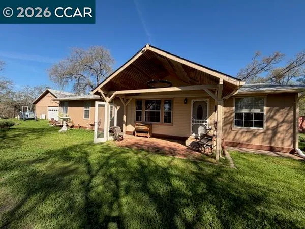 a view of a house with backyard porch and sitting area