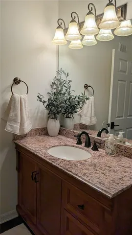 a bathroom with a granite countertop sink a toilet and a mirror