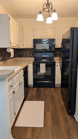 a kitchen with stainless steel appliances a stove refrigerator and cabinets