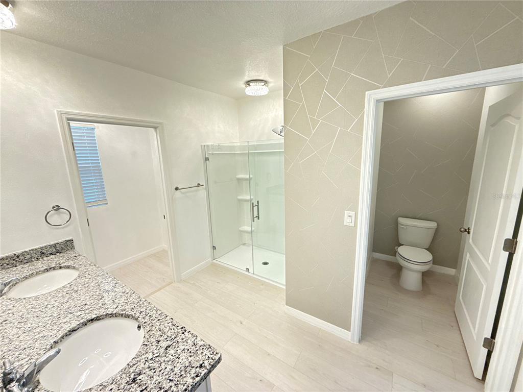 2731 House Finch Road Harmony, FL 34773 - Photo 36 of 57 a bathroom with a granite countertop sink toilet and shower