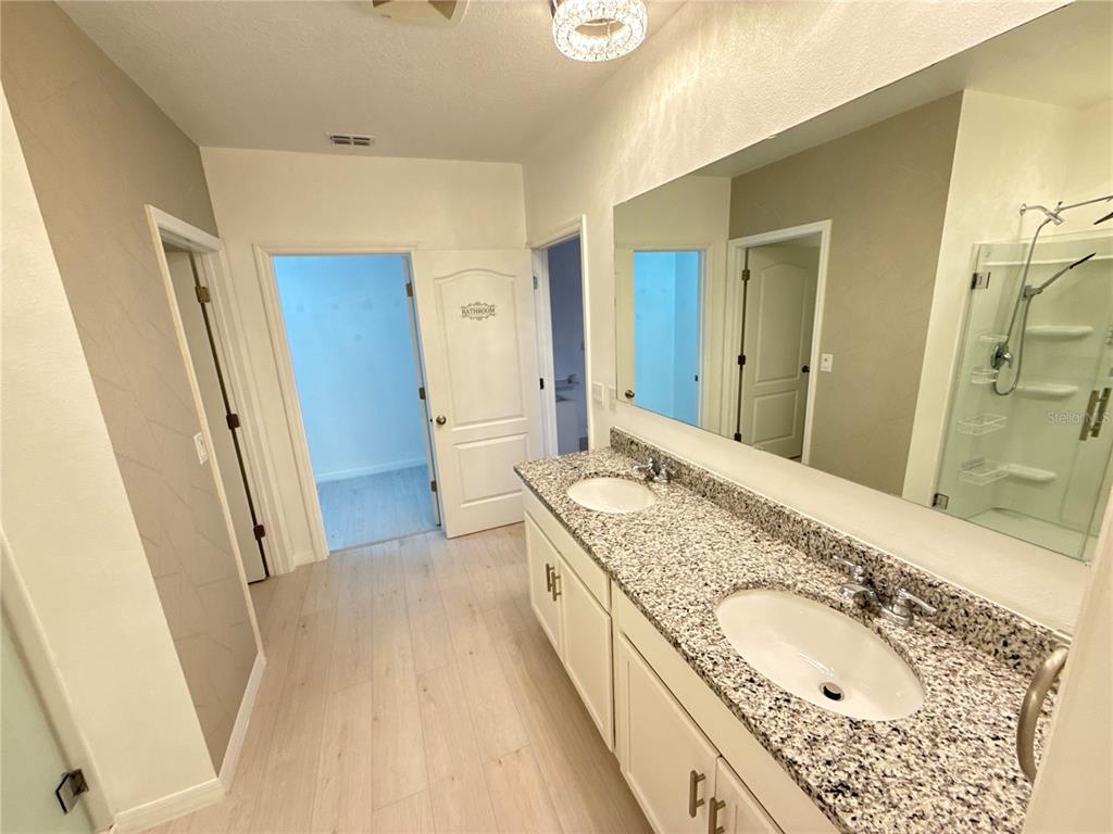 2731 House Finch Road Harmony, FL 34773 - Photo 38 of 57 a bathroom with a granite countertop double vanity sink and a mirror