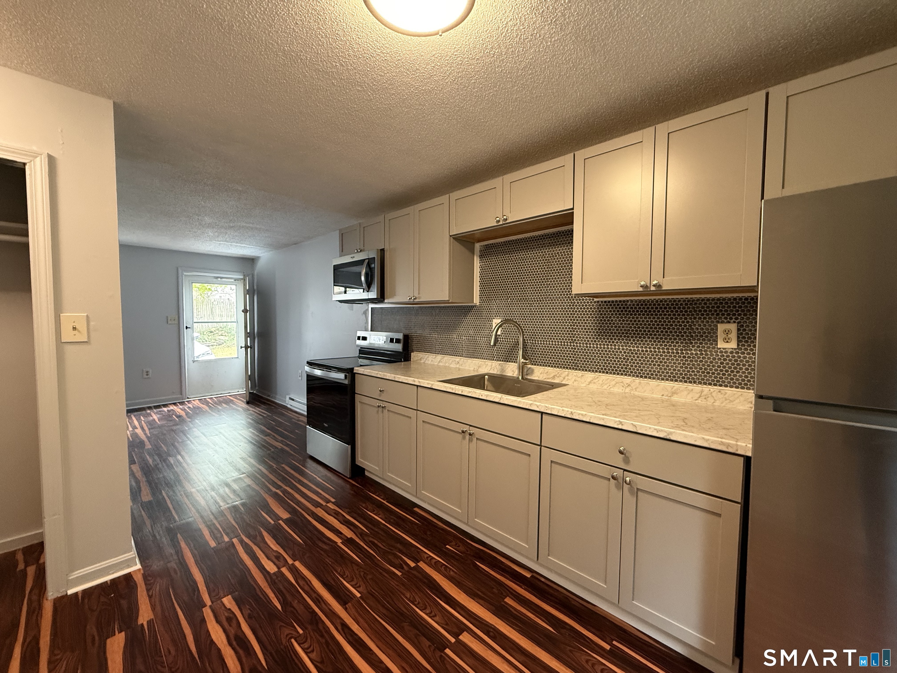 76 Summer Street, Unit 4 New London, CT 06320 - Photo 2 of 9 a kitchen with sink cabinets and wooden floor