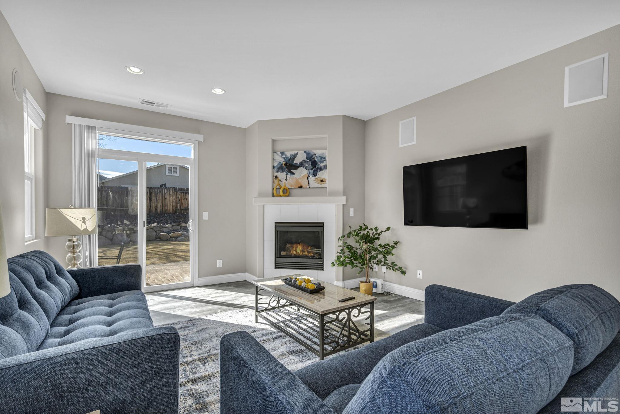 2296 Rio Lobo Lane Reno, NV 89521 - Photo 14 of 33 a living room with furniture a flat screen tv and a fireplace