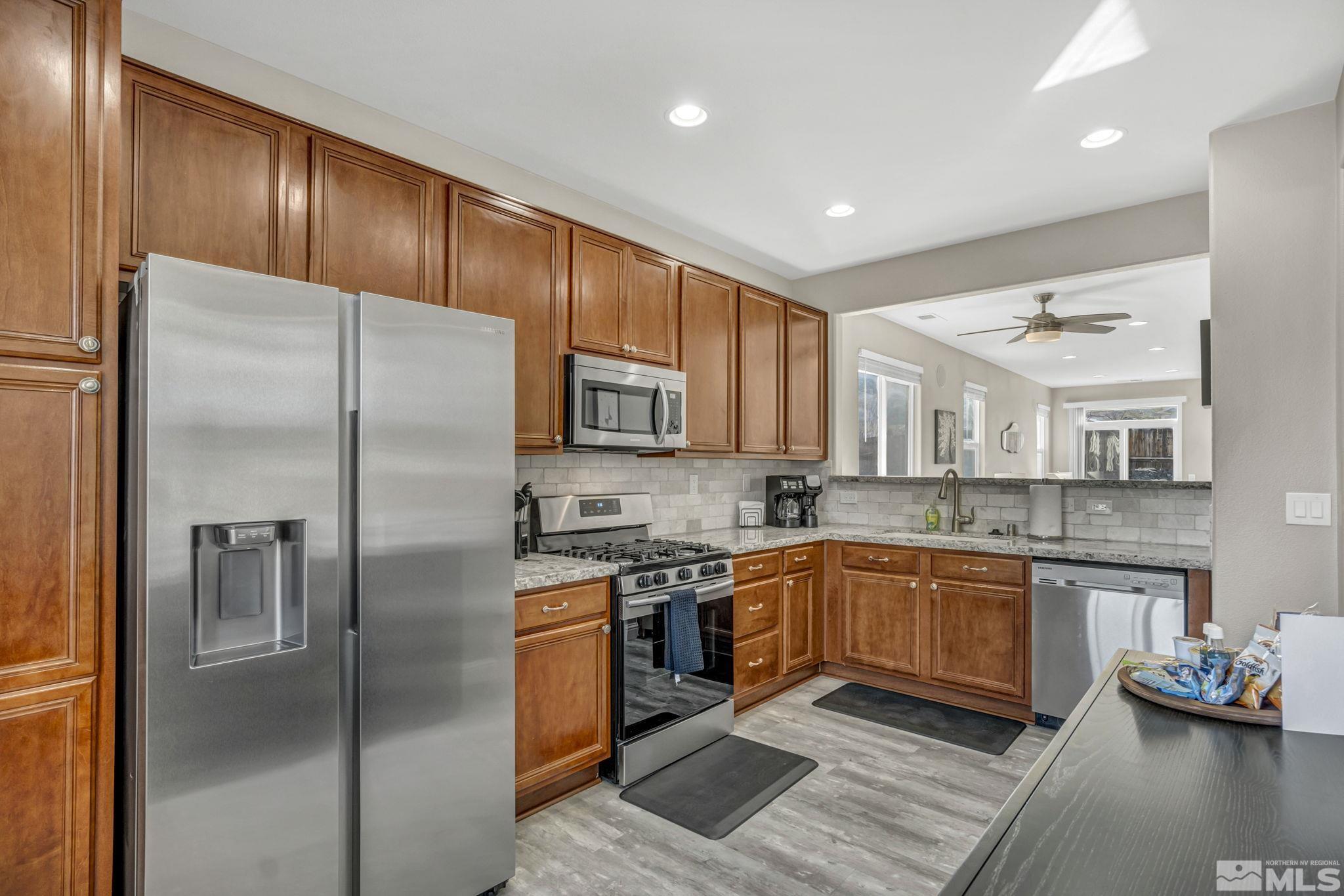 2296 Rio Lobo Lane Reno, NV 89521 - Photo 5 of 33 a kitchen with stainless steel appliances granite countertop a refrigerator a sink dishwasher a stove with wooden cabinets and floor