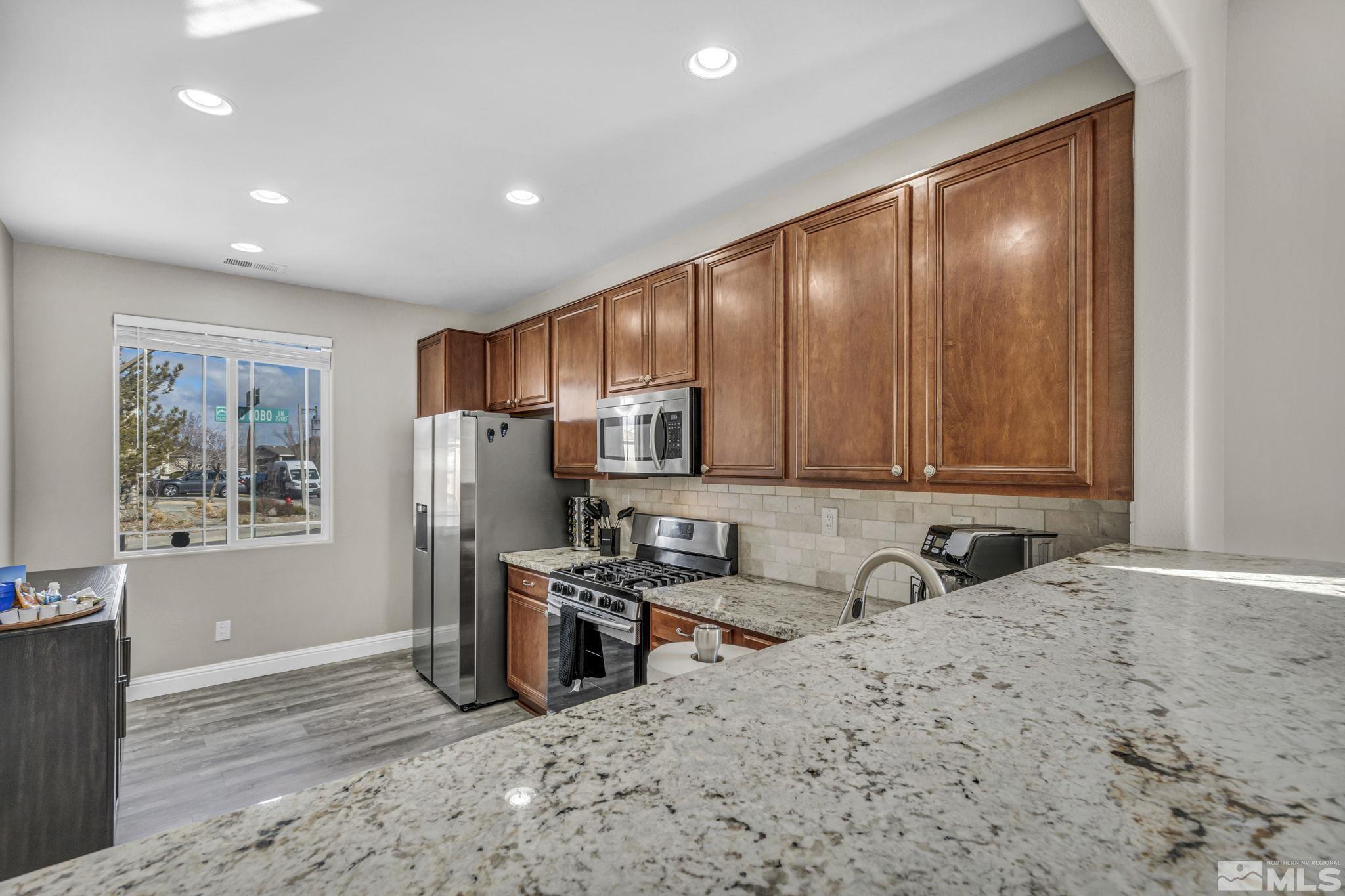 2296 Rio Lobo Lane Reno, NV 89521 - Photo 8 of 33 a view of a kitchen with refrigerator stove and wooden floor