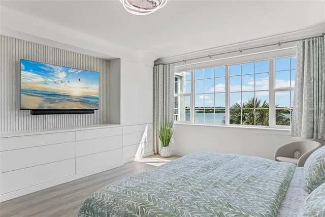 a living room with a bed furniture and next to a window