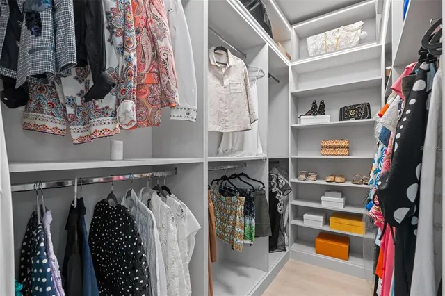 a view of walk in closet with clothes and shoes