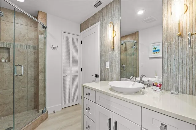 a bathroom with a shower sink and mirror