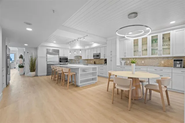 a kitchen with stainless steel appliances kitchen island granite countertop a table and chairs