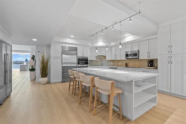 a kitchen with kitchen island granite countertop a refrigerator and a stove top oven