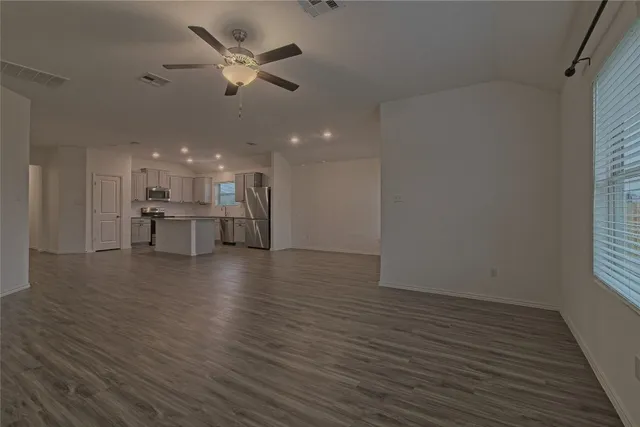 en empty room with windows and ceiling fan