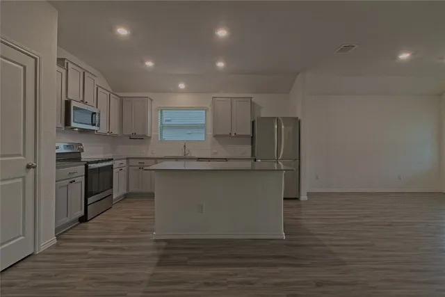 a kitchen with stainless steel appliances granite countertop a stove a sink and a refrigerator