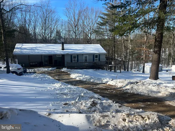 a view of a house with snow on the side of the road