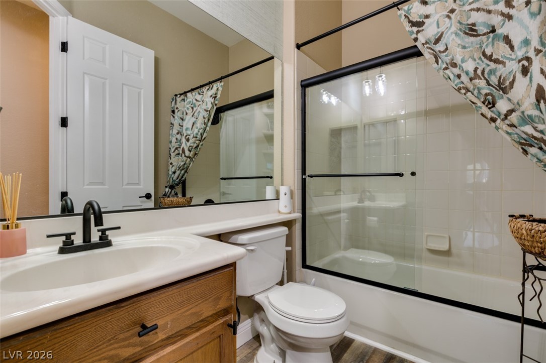 7524 Midnight Rambler Street Las Vegas, NV 89149 - Photo 31 of 51 A well-appointed bathroom features a single vanity, modern fixtures, and a shower-tub combination with sleek glass doors.