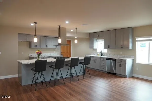 a kitchen with stainless steel appliances granite countertop a sink a stove a microwave a dining table and chairs