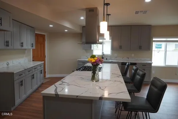 a kitchen with stainless steel appliances granite countertop table chairs sink and cabinets