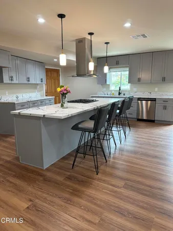 a living room with furniture a fireplace and a dining table with wooden floor