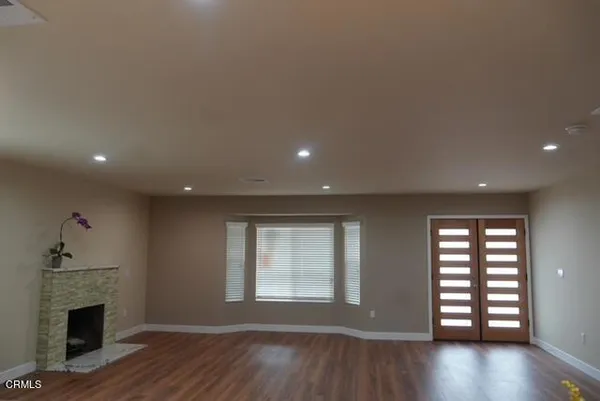 a view of empty room with wooden floor and fireplace