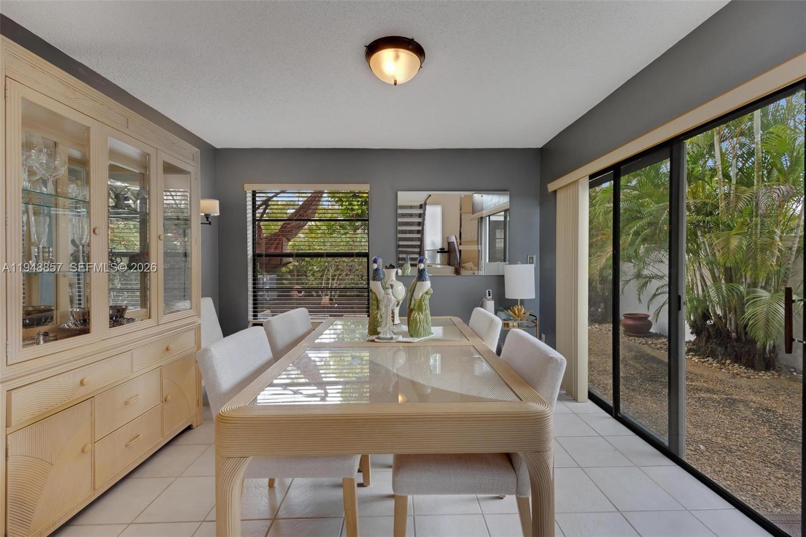 11769 Southwest 91st Terrace Miami, FL 33186 - Photo 7 of 33 a view of a dining room with furniture large windows and chandelier