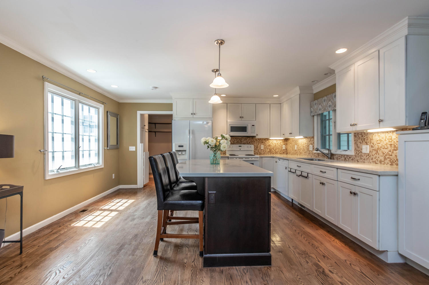 4 Moore Street Darien, CT 06820 - Photo 9 of 30 a kitchen with granite countertop a dining table chairs wooden cabinets and white appliances