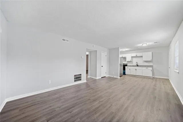 a view of a kitchen with wooden floor and windows