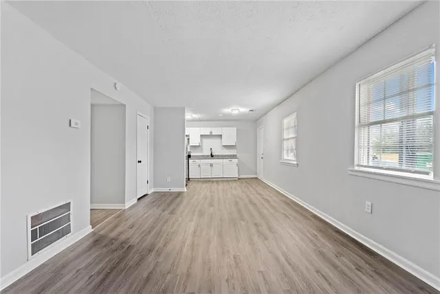 a view of a kitchen with wooden floor and windows