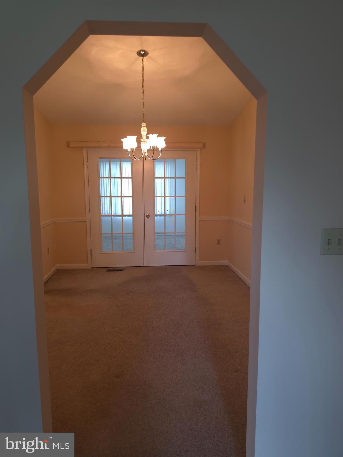 142 Braddock Boulevard Inwood, WV 25428 - Photo 14 of 36 an empty room with chandelier fan and kitchen view