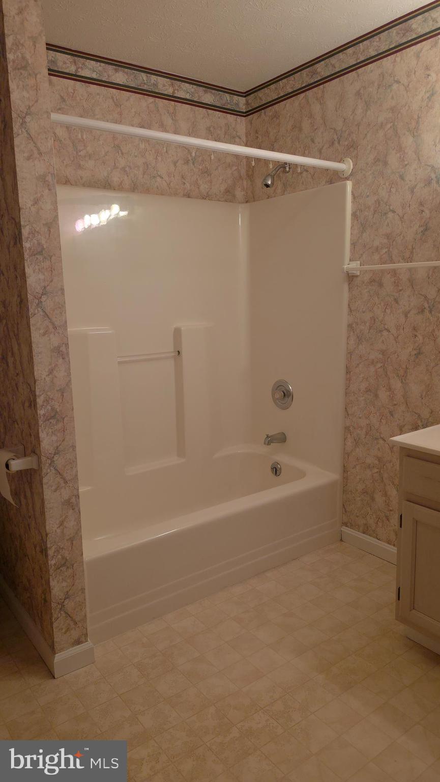 142 Braddock Boulevard Inwood, WV 25428 - Photo 22 of 36 a bathroom with a shower and a bath tub
