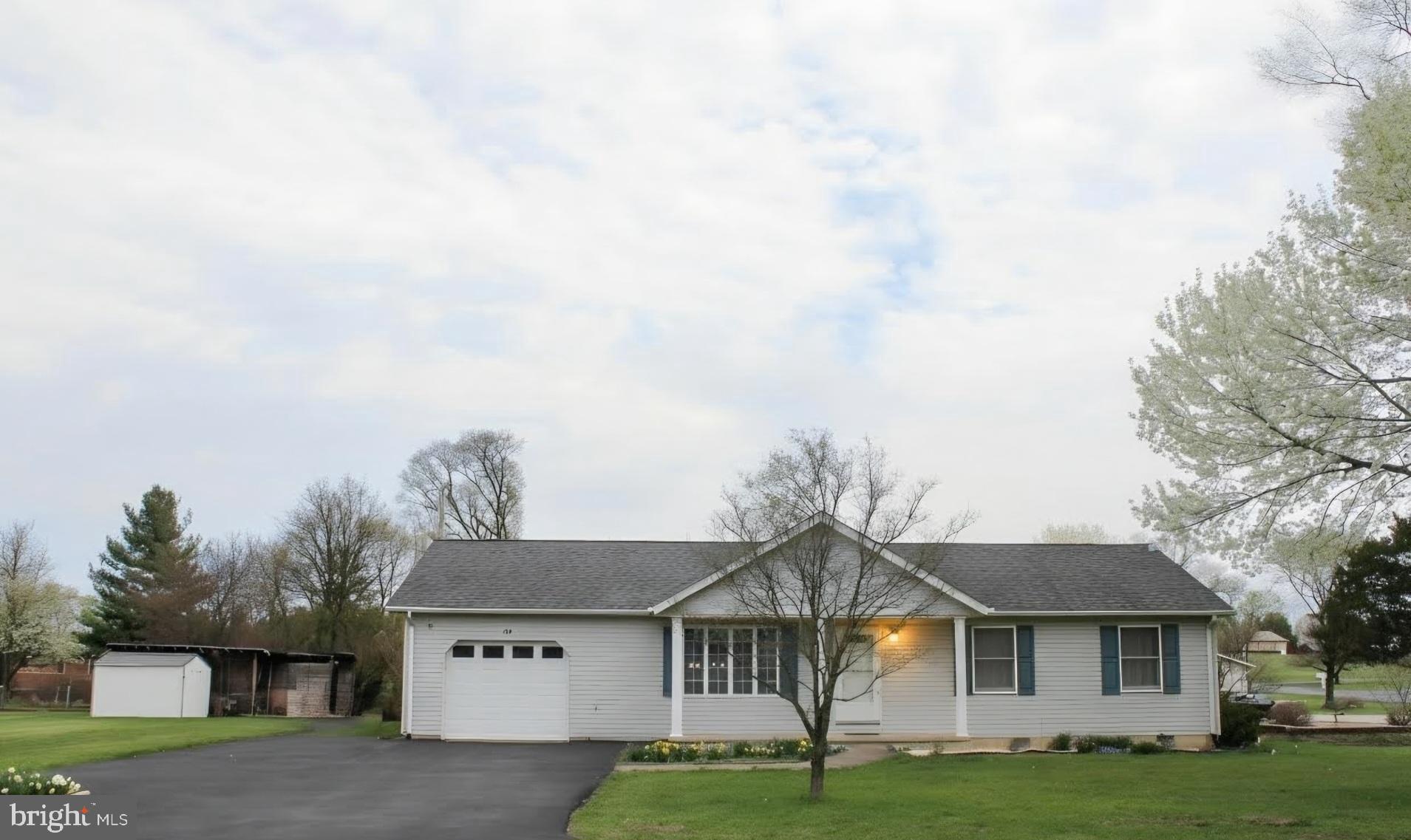 142 Braddock Boulevard Inwood, WV 25428 - Photo 4 of 36 a front view of a house with a garden and yard