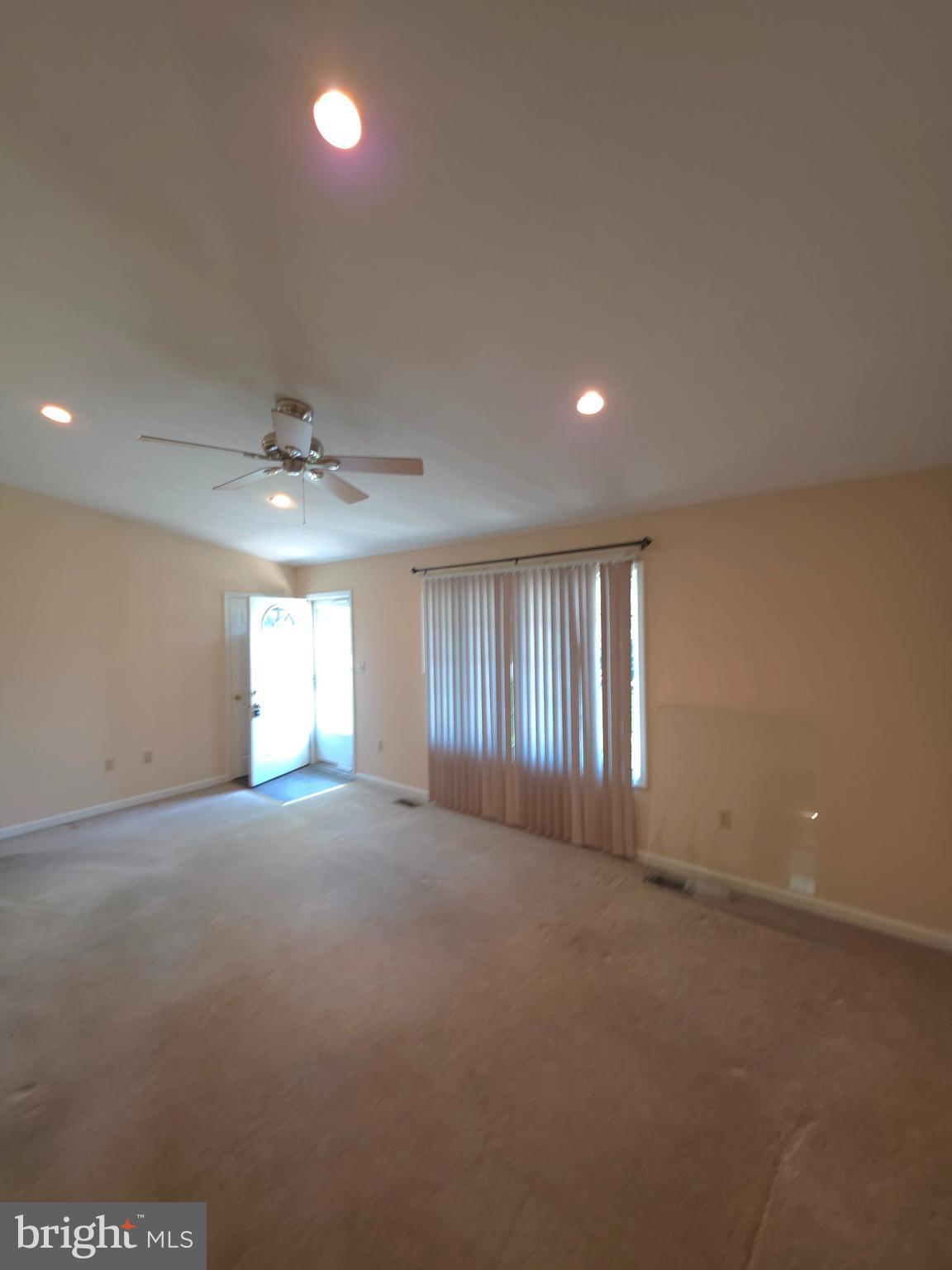 142 Braddock Boulevard Inwood, WV 25428 - Photo 9 of 36 an empty room with windows and chandelier fan