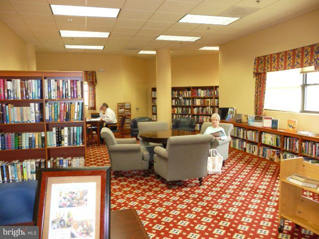 19355 Cypress Ridge Terrace, Unit 807 Leesburg, VA 20176 - Photo 4 of 29 a living room with couches a coffee table and bookshelf