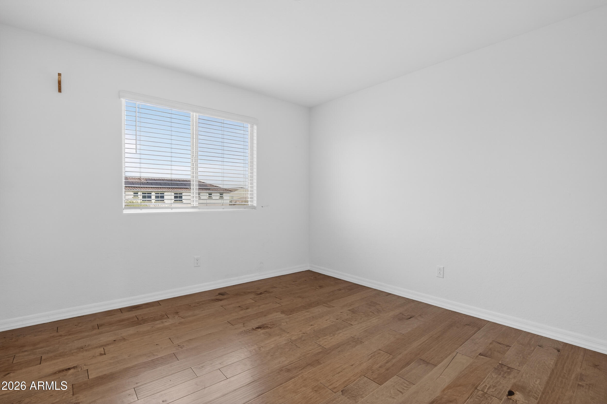 15177 West Desert Bloom Street Goodyear, AZ 85338 - Photo 31 of 55 wooden floor in an empty room with a window