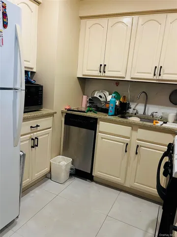 a kitchen with white cabinets and appliances
