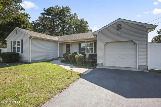 a front view of house with yard and trees around