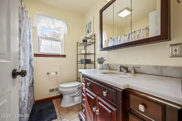 a bathroom with a granite countertop sink a toilet and a mirror