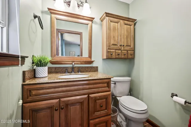 a bathroom with a toilet a sink and a mirror