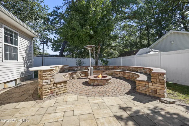 a view of a patio with table and chairs and wooden fence