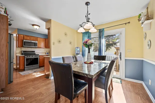 a view of a dining room with furniture a chandelier and wooden floor