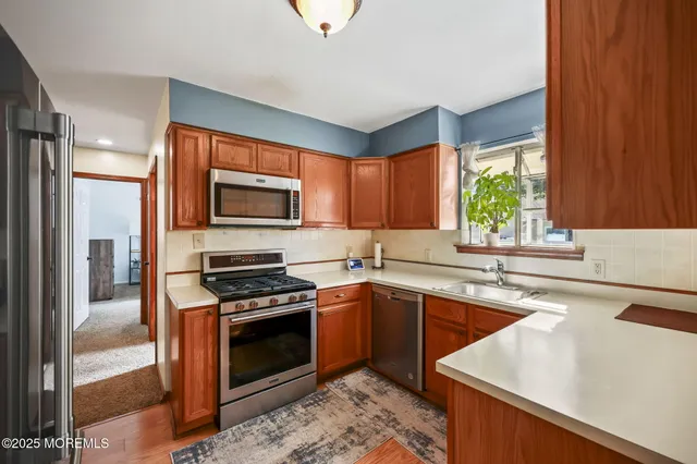 a kitchen with stainless steel appliances a stove sink microwave and refrigerator