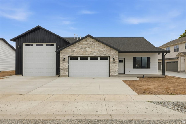 164 North 400 East Preston, ID 83263 - Photo 1 of 21 Contemporary-style property featuring a stone and siding exterior, two attached garages with white doors, and a covered entry
