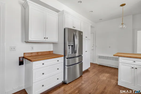 a kitchen with granite countertop a refrigerator and a stove top oven