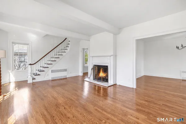 a view of a livingroom with wooden floor and a fireplace