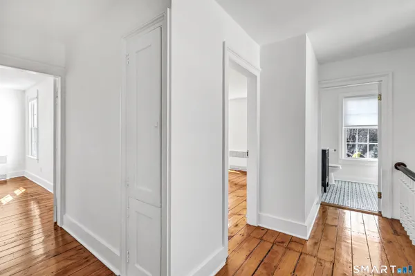 a view of a hallway with wooden floor and staircase