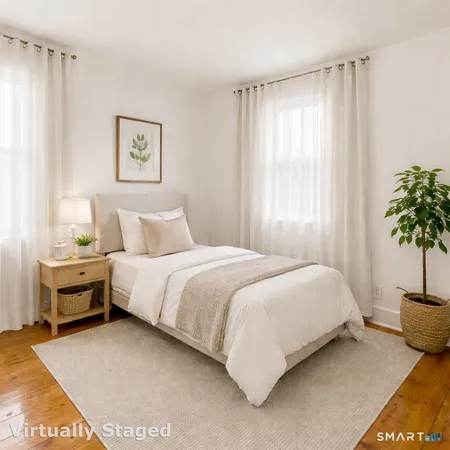 a bedroom with a bed and a potted plant