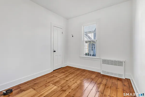 a view of empty room with wooden floor