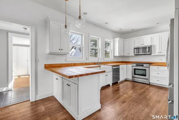 a kitchen that has a lot of cabinets in it and wooden floors
