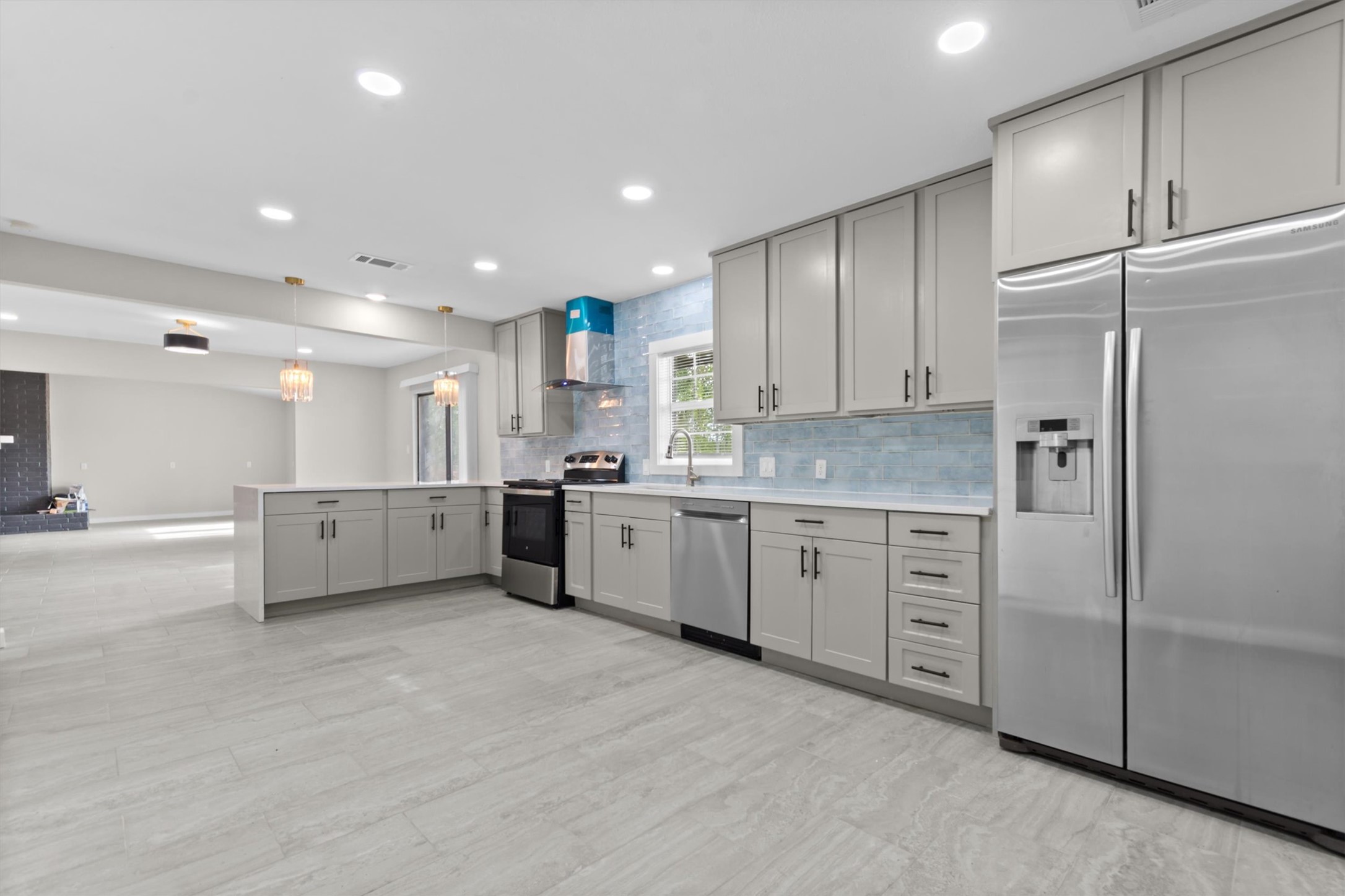 9100 Highway 183 Austin, TX 78747 - Photo 13 of 38 Streamlined cabinetry and continuous stone-look tile flooring anchor this airy, open-concept culinary workspace.